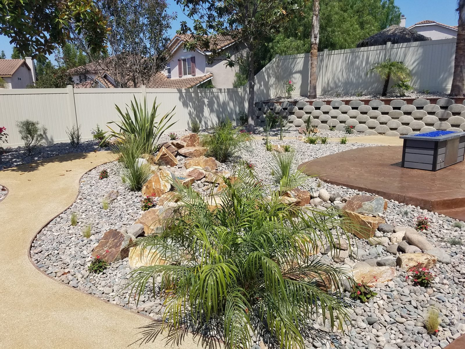 Quintero Residence — Checkerboard turf-and-paver design with boulders